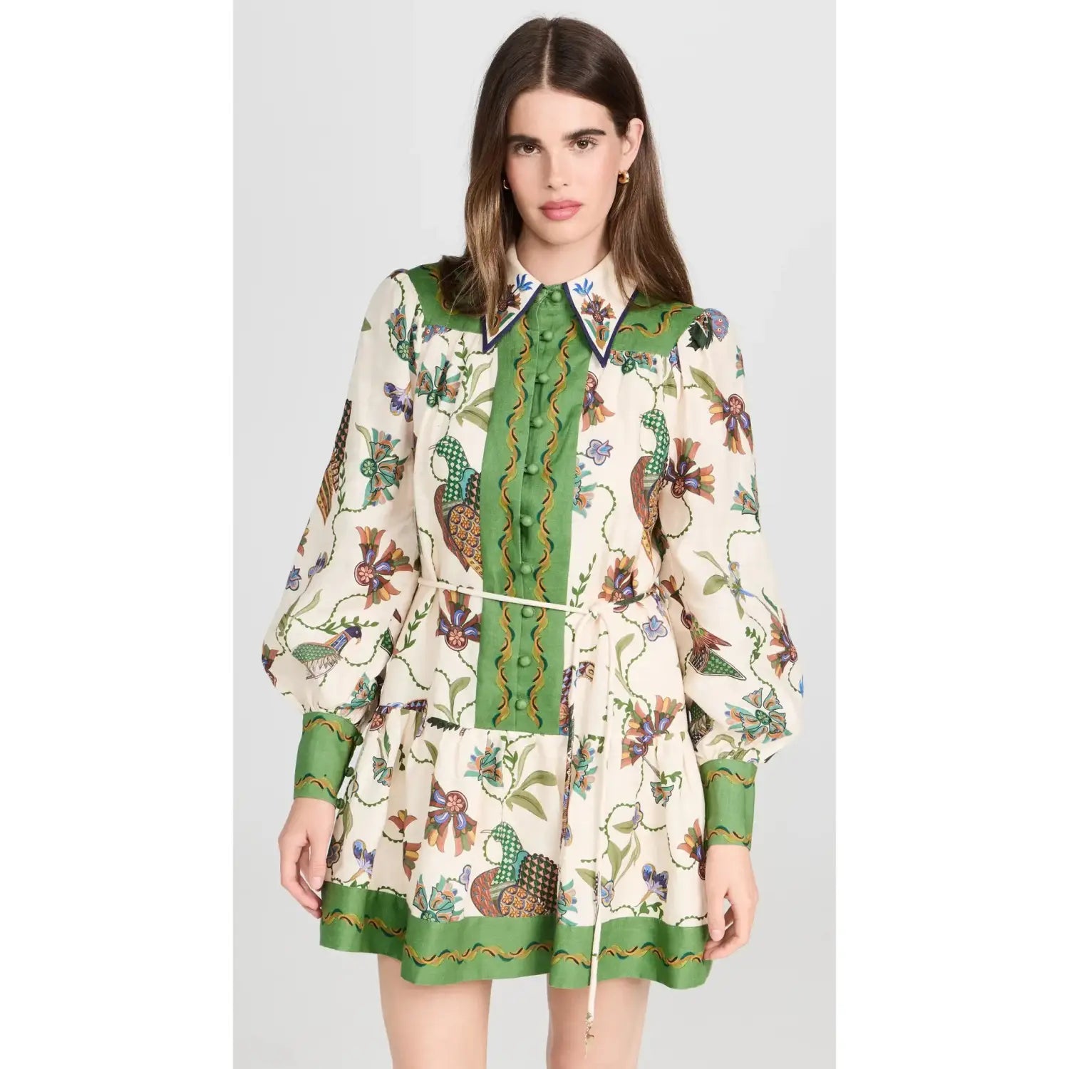 A cream-colored botanical print puff sleeve midi dress with a vibrant green collar, cuffs, and hemline featuring an intricate pattern of birds, flowers, and vines in earthy tones.