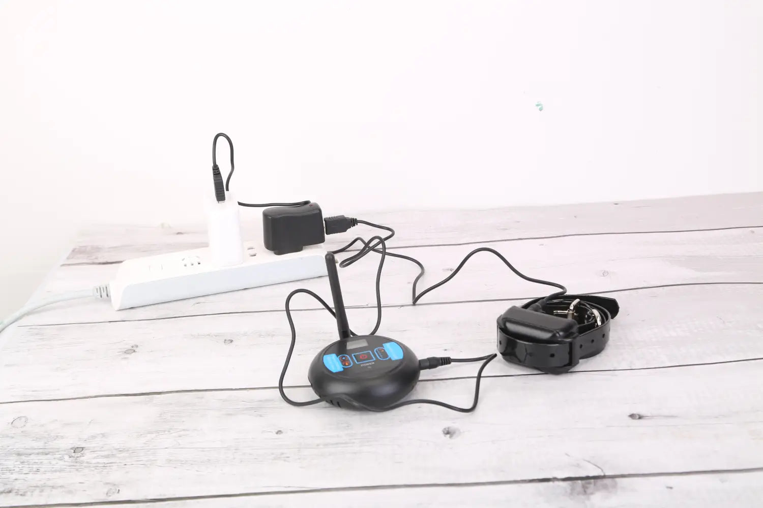 Black wireless dog fence system waterproof training collar with blue illuminated buttons and small antenna.