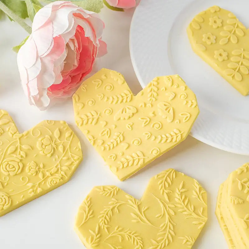 Dessous-de-verre en bois de hêtre en forme de cœur jaunes, avec un relief floral et de feuilles complexe, conçus pour être utilisés avec le rouleau à pâtisserie en bois de hêtre en relief floral pour la cuisson