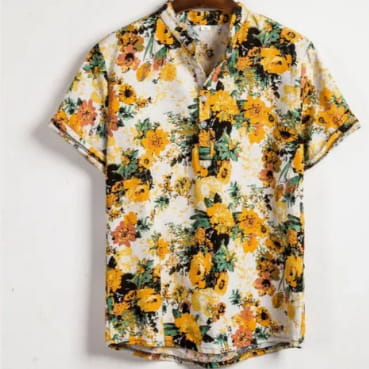 A vibrant yellow and orange floral print Hawaiian short sleeve shirt for men featuring green leaves on a white background hanging neatly on a wooden hanger.