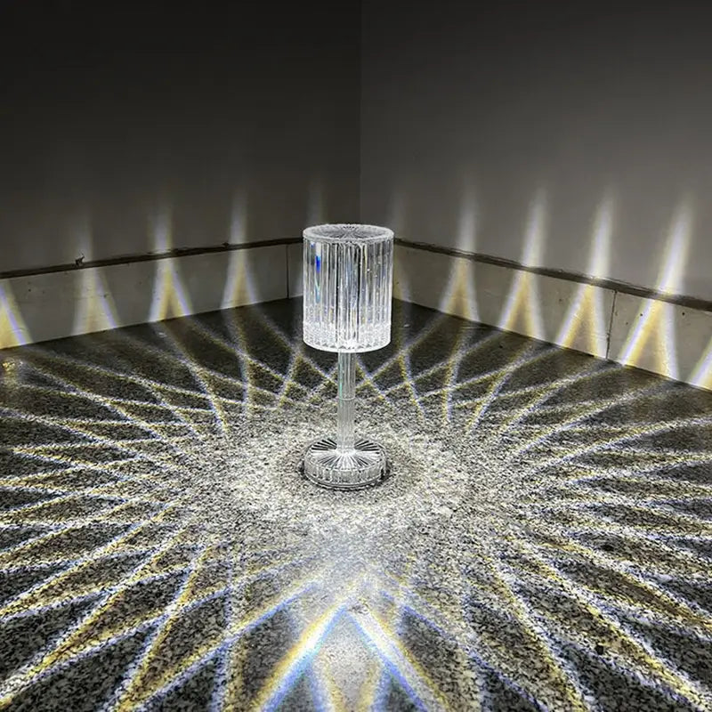 Crystal table lamp with vertical ridges and a fluted base in clear crystal featuring 3 way dimmable touch control that casts radiant geometric light patterns.