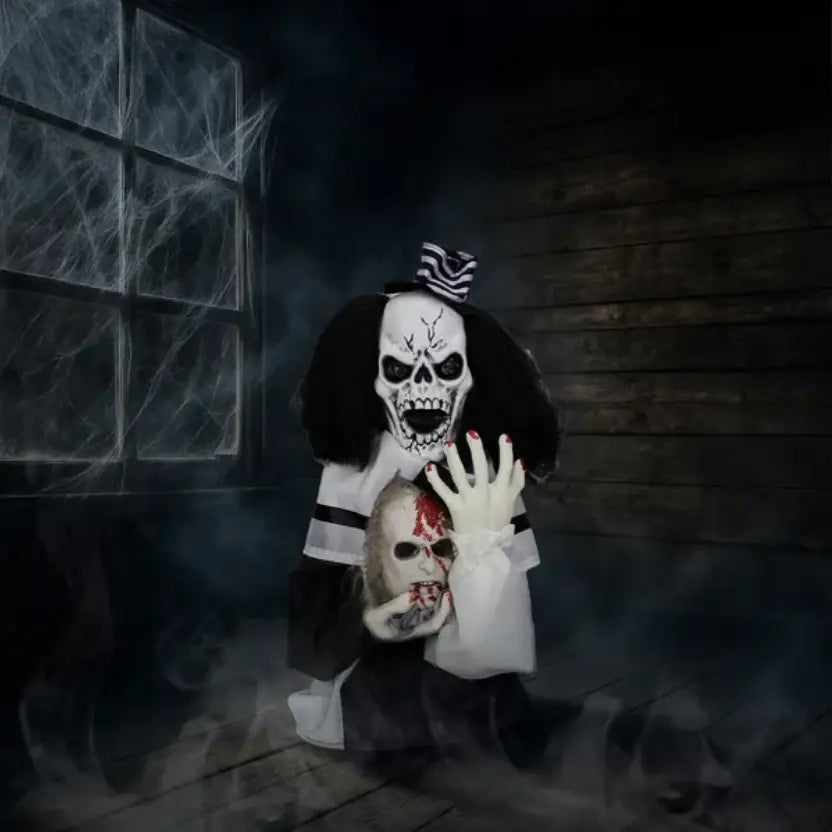 A black and white scary clown Halloween decoration with a skull mask, long curly hair, striped bow tie, holding a bloody face mask, sound activated and 1.8 feet tall.