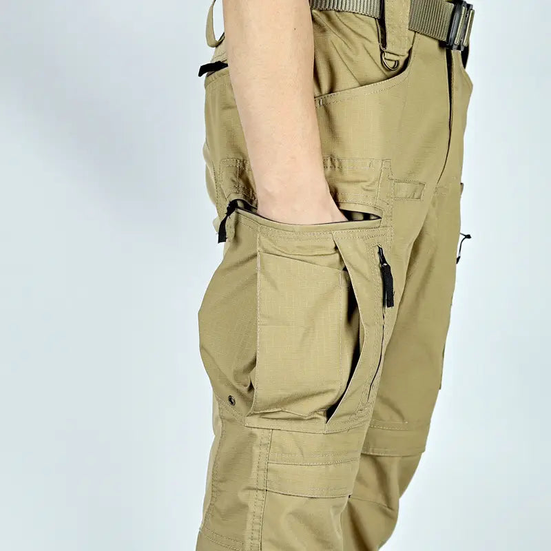 Pantalons cargo tactiques beige avec plusieurs poches zippées et poches à rabat, fabriqués dans un tissu durable et avec des coutures renforcées, conçus pour un usage militaire dans la collection « Pantalons tactiques P40 pour hommes, multi-poches ».