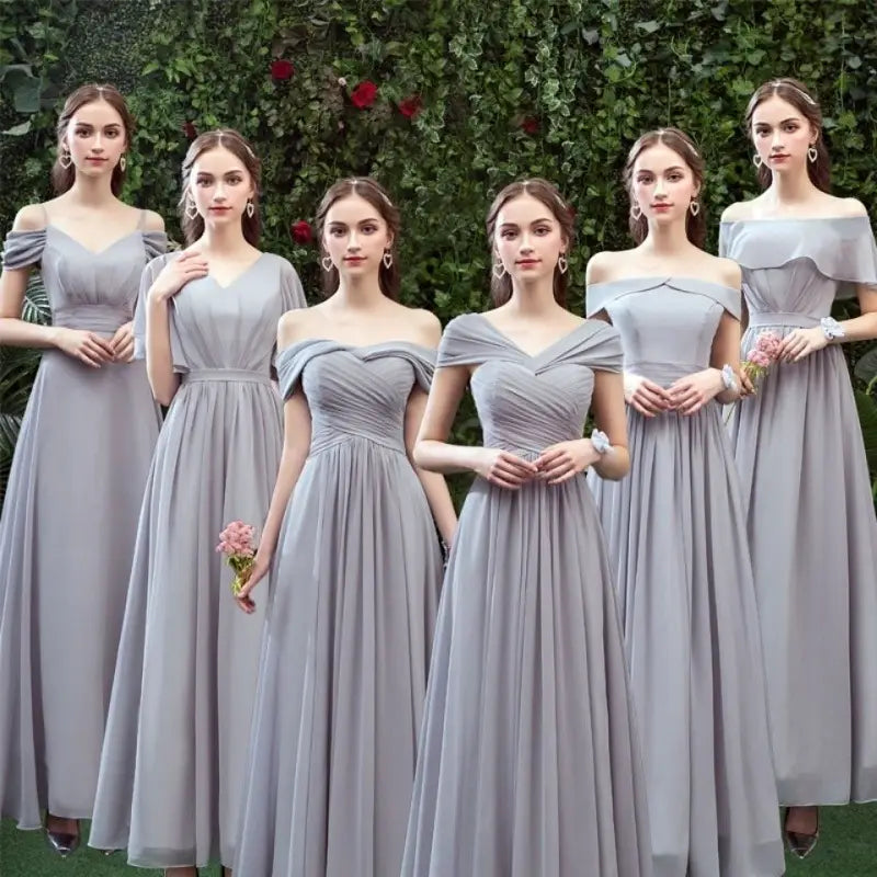 six bridesmaids wear matching off-the-shoulder gray chiffon floor-length bridesmaid gowns with ruched bodices and flowing skirts.