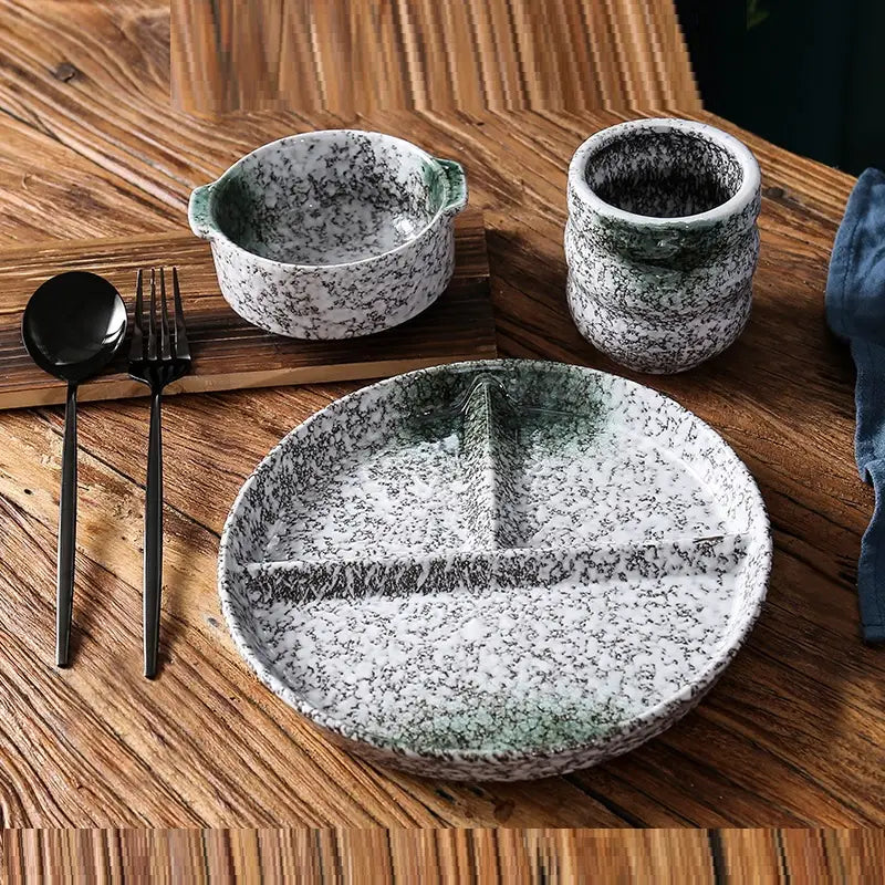 Service d’assiettes de dîner divisées en céramique avec glaçure à mouchetures, comprenant une assiette en céramique blanche avec des éclaboussures noires et un rebord dégradé vert, divisé en trois sections par des nervures en relief.