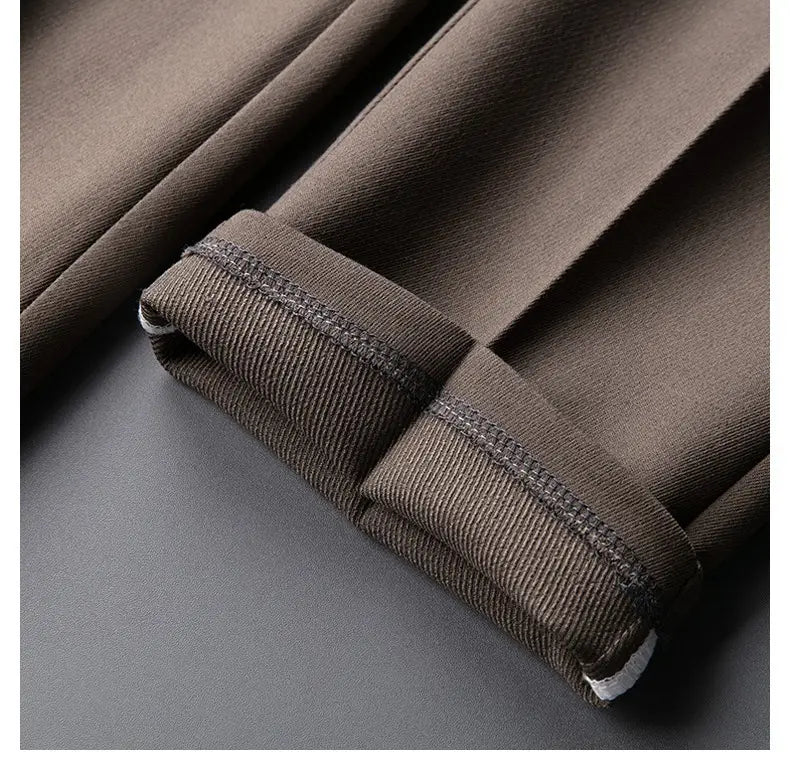 Men’s slim fit British style tailored straight leg trousers in dark brown featuring pleats, ribbed cuffs, and contrasting stitching.