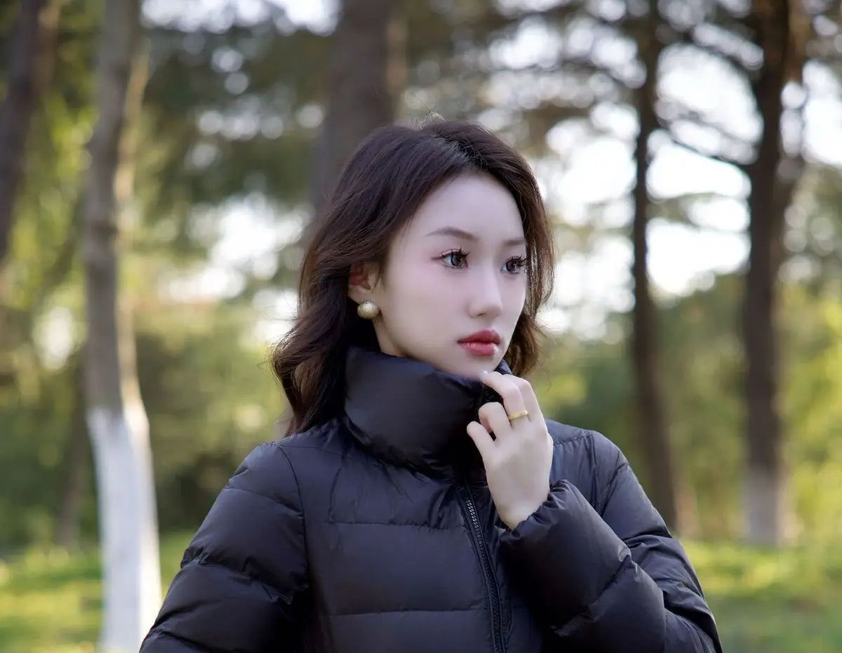 Schwarze kurze Steppjacke aus Daunen für Damen mit Puffer-Design und hohem Kragen, ideal für Winterbekleidung.