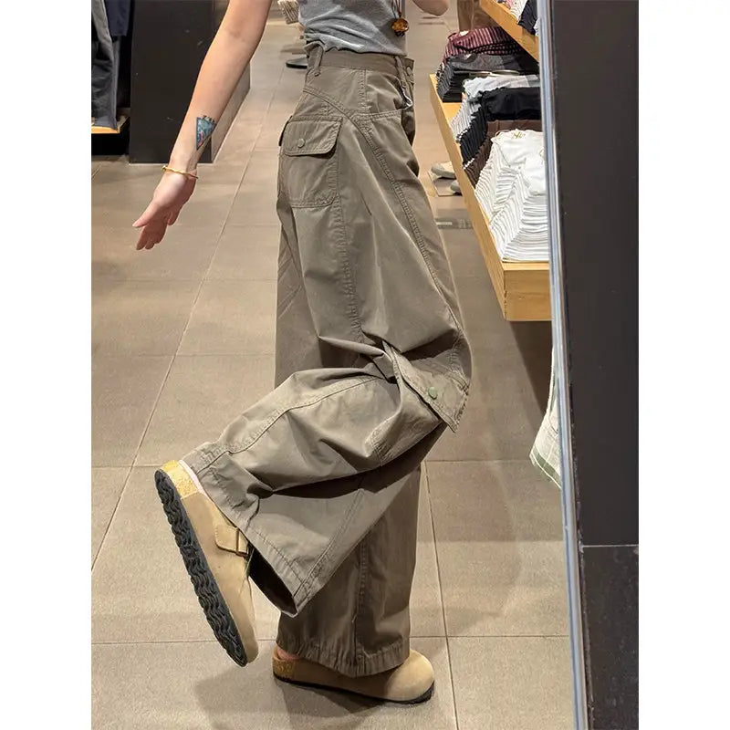 Pantalon cargo femme beige à taille haute et jambe large, avec plusieurs poches et coupe ample.