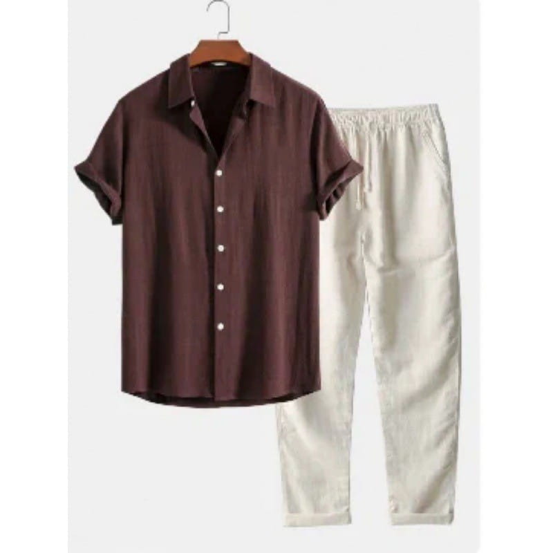 Ensemble chemise pour homme à manches courtes et pantalon comprenant une chemise brune à manches courtes boutonnée, avec un col et des boutons blancs, suspendue sur un cintre en bois.