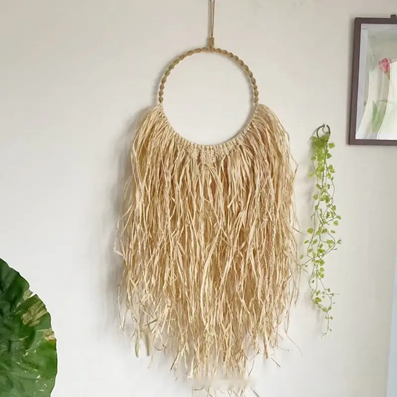 Adorno de pared de rafia de fibra natural estilo boho, tapiz colgante de macramé con marco superior circular y largas hebras que caen con fluidez.