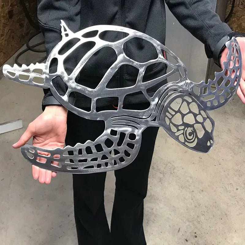 Wanddekoration aus silbernem Metall mit Meeresschildkrötenmotiv zeigt ein minimalistisches Gitterdesign, das für die Deko zum Thema Meerestiere geeignet ist.