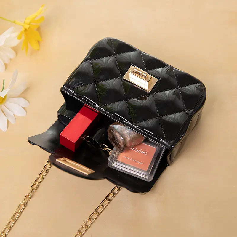 Mini quilted pearl crossbody bag for women in black quilted patent leather with gold-tone hardware and chain strap.