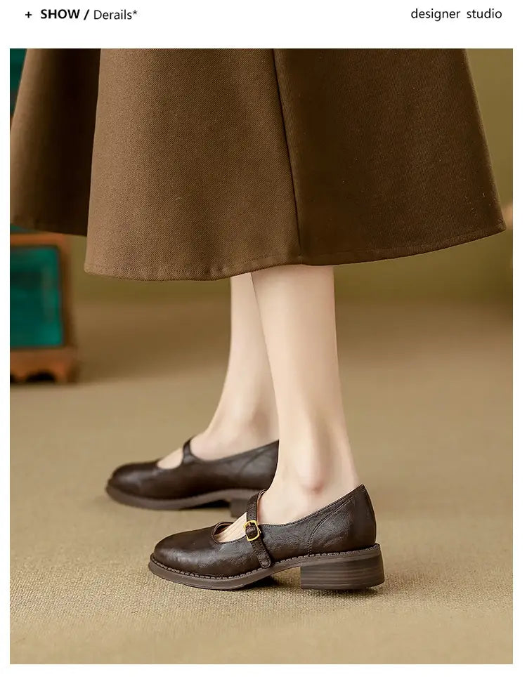 Dark brown leather mary jane flats with a low block heel and gold toned buckle for elegant and comfortable wear.