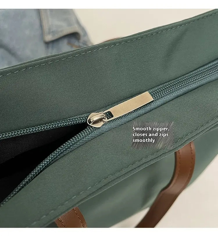Large capacity canvas tote bag with leather handles featuring dark green nylon material brown leather handles and a silver zipper.