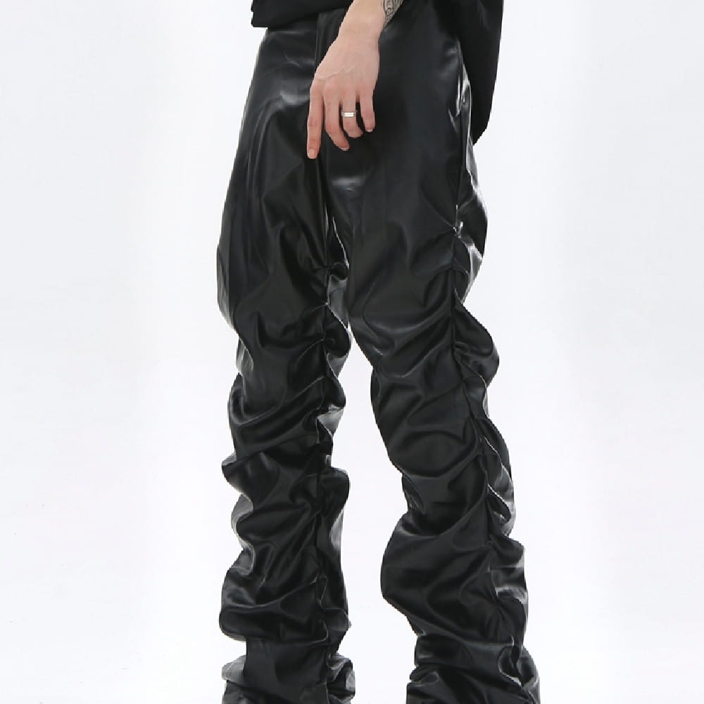 Men’s black ruched glossy faux leather tapered pants featuring textured detailing along the legs.