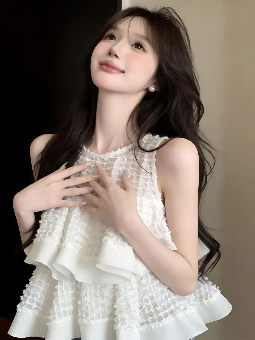 Blusa negra sin mangas con volante fruncido que presenta un top blanco con volante fruncido de encaje, tejido de malla con textura y un delicado ribete con cuentas a lo largo del escote.