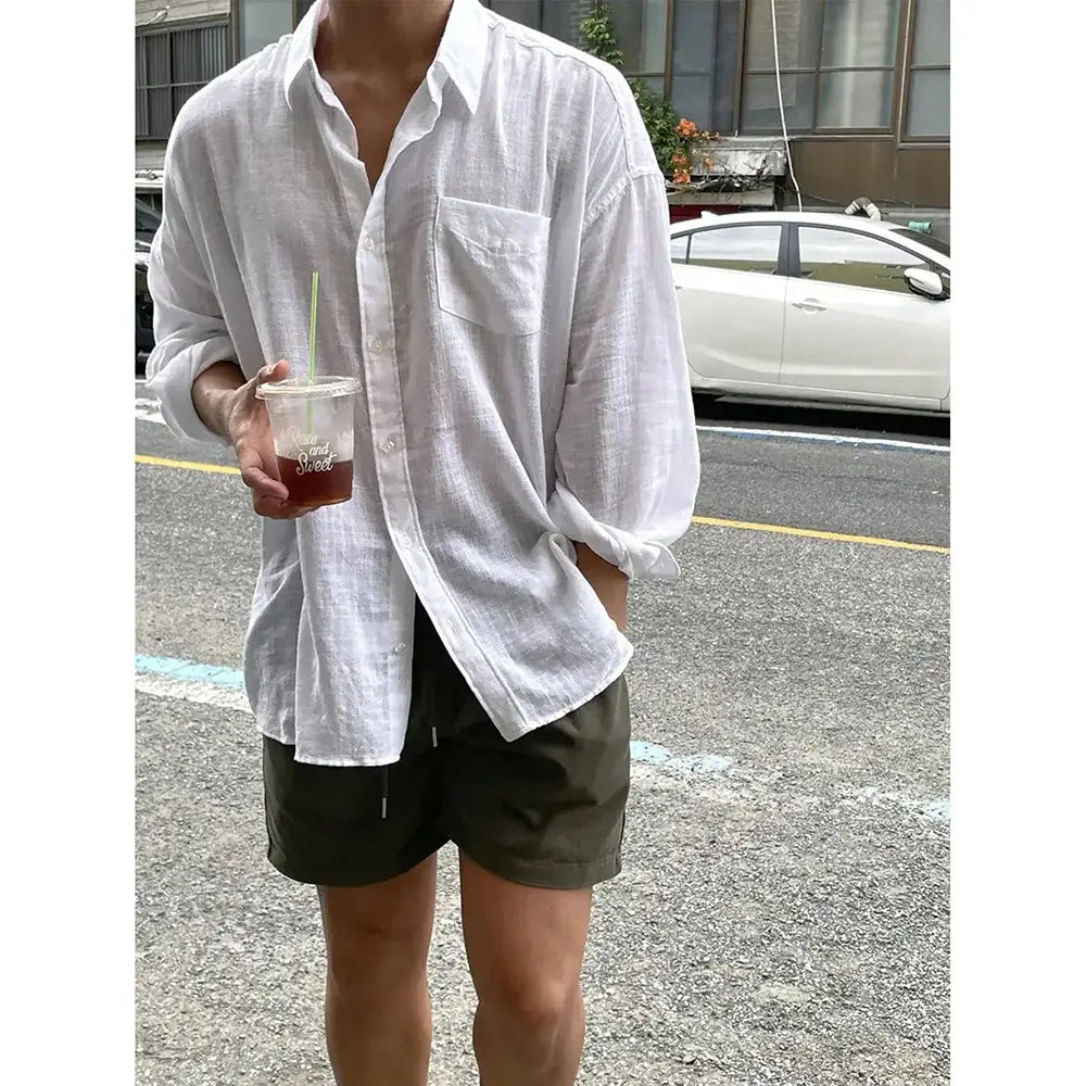 White loose-fitting Korean style linen button-up shirt with textured fabric and rolled sleeves.