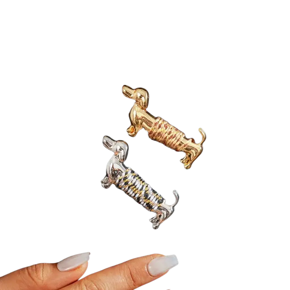 Two dachshund brooches featuring a gold-tone textured body and a silver-tone black and white striped design lapel pin