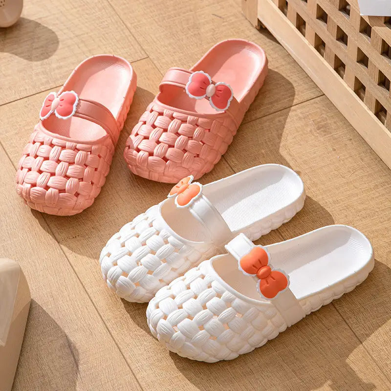 pink and white woven pvc slide sandals with bow decorations designed for summer beach use