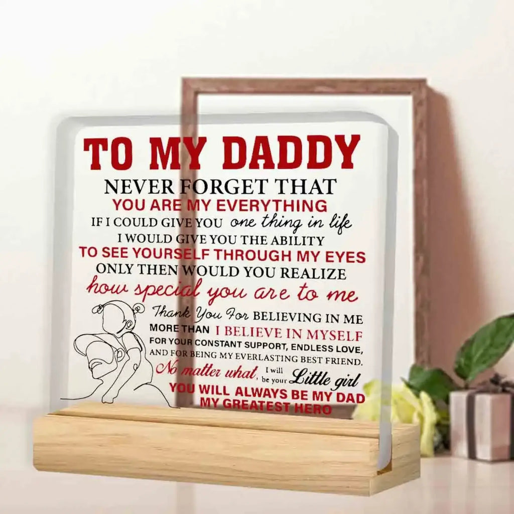 Clear acrylic daddy desk sign with heartfelt red and black text and illustration of child embracing adult daughter gift