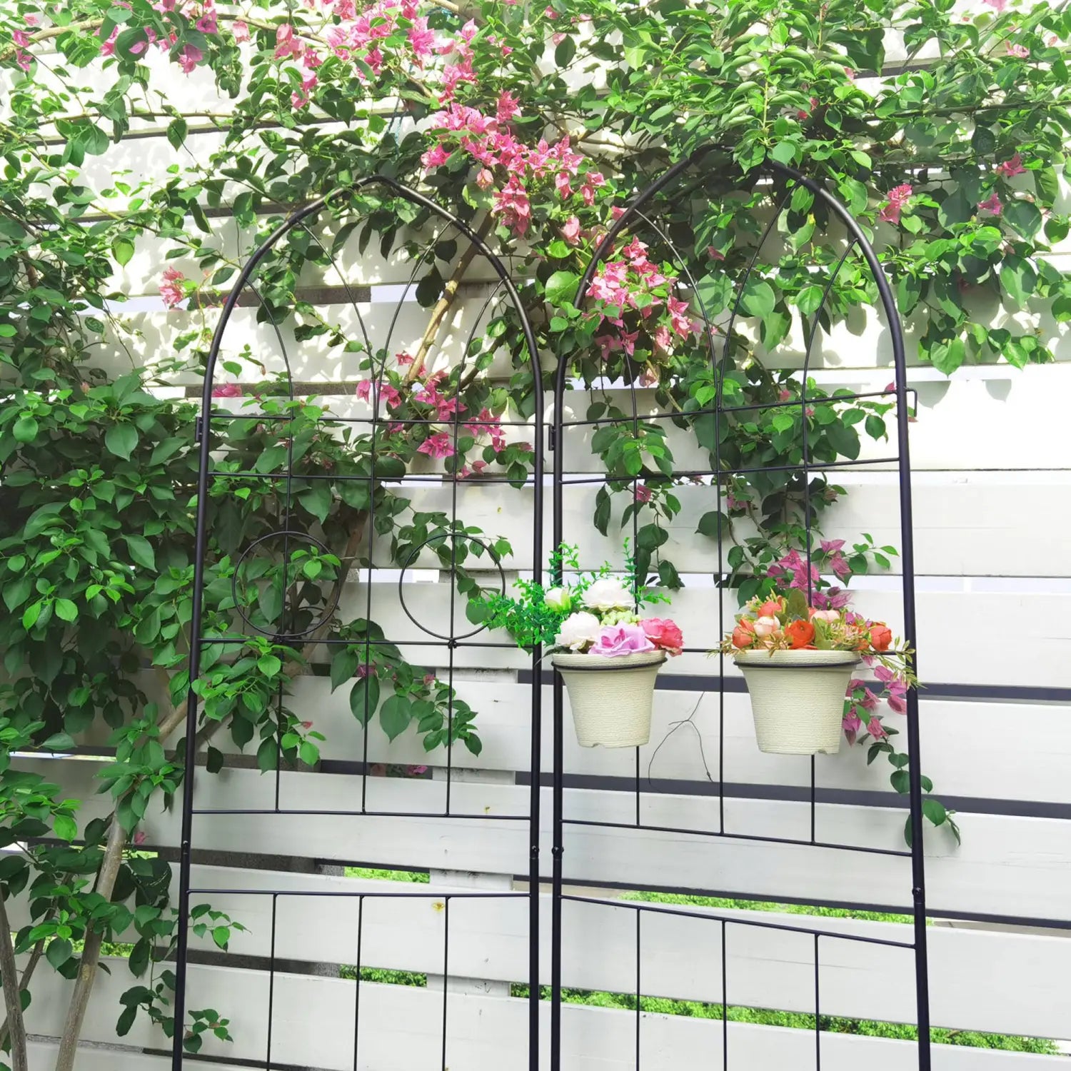 Black wrought iron arched metal garden trellis 4 pack with circular decorative elements and hanging planters for climbing plants.
