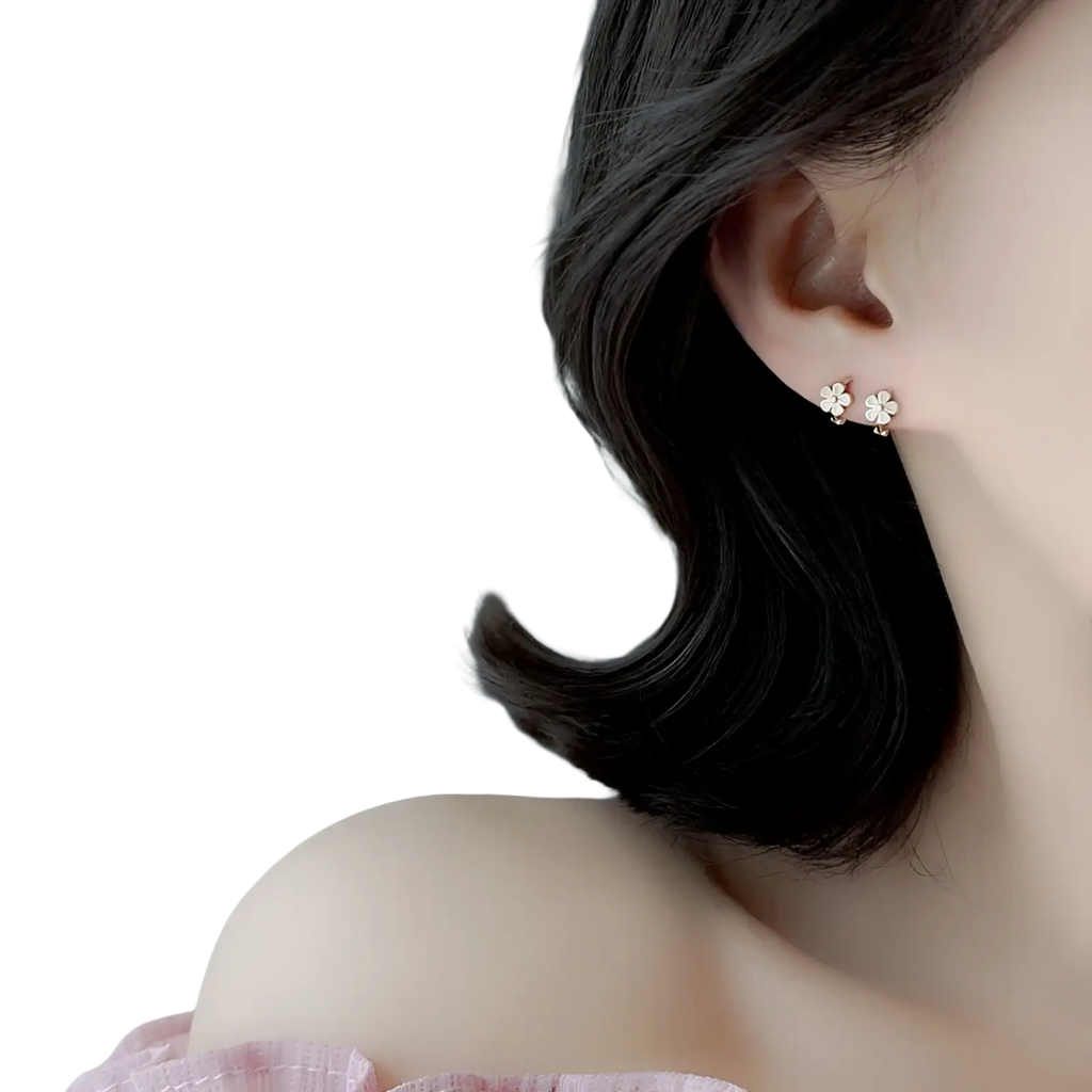 Delicate gold-toned daisy enamel flower clip on and stud earrings with tiny clear gemstones at the center