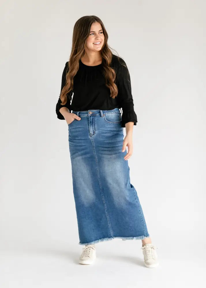 A mid-blue dakotah high waisted denim maxi skirt with a raw frayed hem and classic front pockets