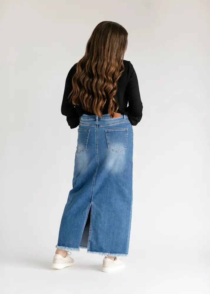 Dakotah raw hem high waisted denim maxi skirt in mid-blue with front slit and frayed hem made of denim material