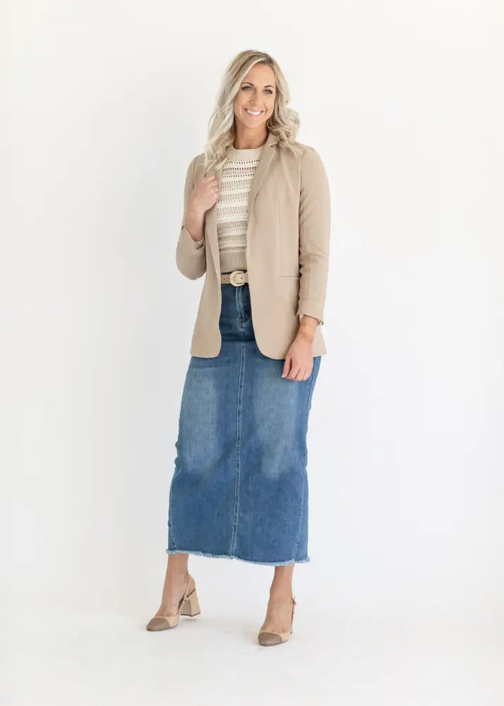 Beige structured blazer with subtle texture worn over striped top paired with dakotah raw hem high waisted denim maxi skirt