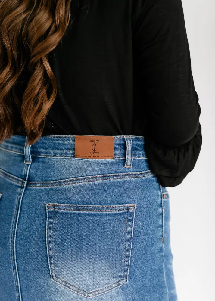 Dakotah raw hem high waisted denim maxi skirt in blue denim with a brown leather brand patch on the back waistband