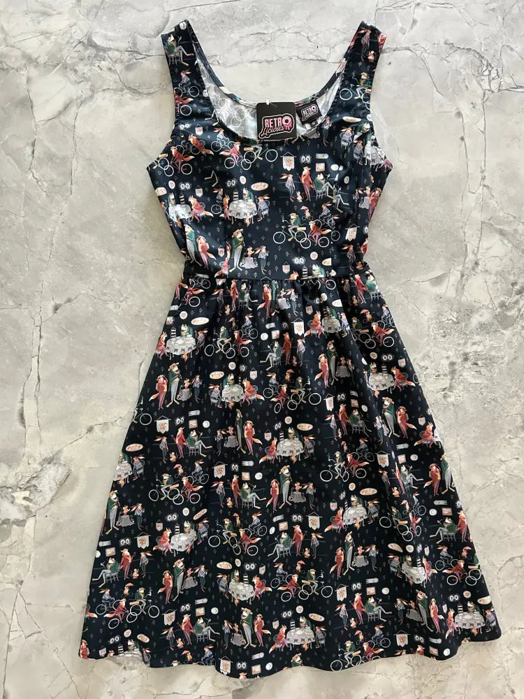 A black sleeveless fit and flare dress by dapper fox featuring a vibrant retro print of cyclists and vintage street scenes