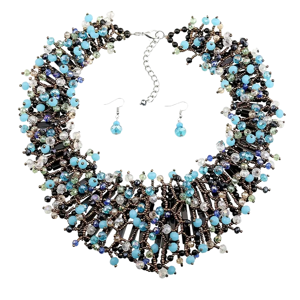 A dark blue crystal statement necklace with intricate turquoise black and clear beads in a dark metallic framework