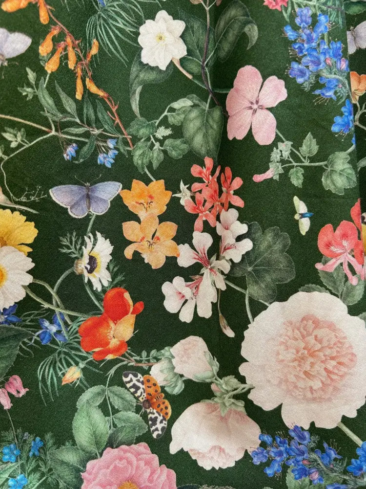 Dark floral doris high waisted cotton midi skirt with pockets featuring dark green fabric and vibrant floral butterfly print