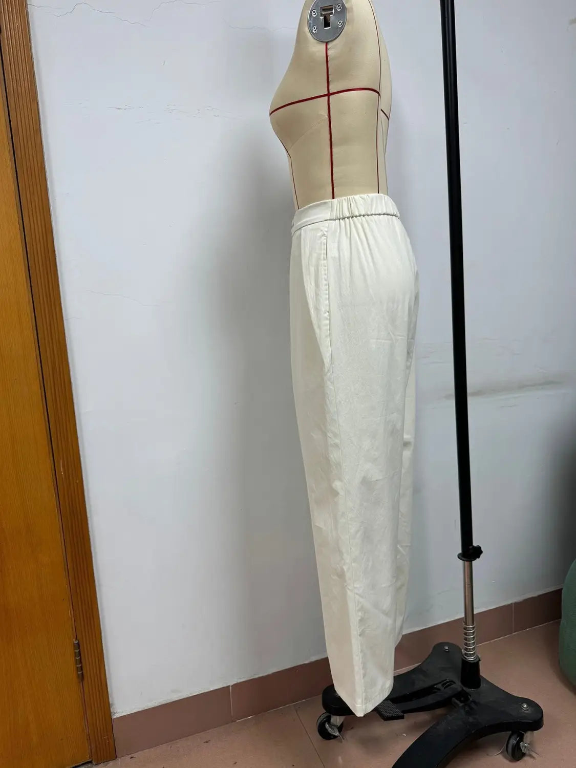 Pantalons blancs à taille haute et jambes larges présentant une ceinture élastique et des coutures verticales discrètes, parfaits pour un look soigné