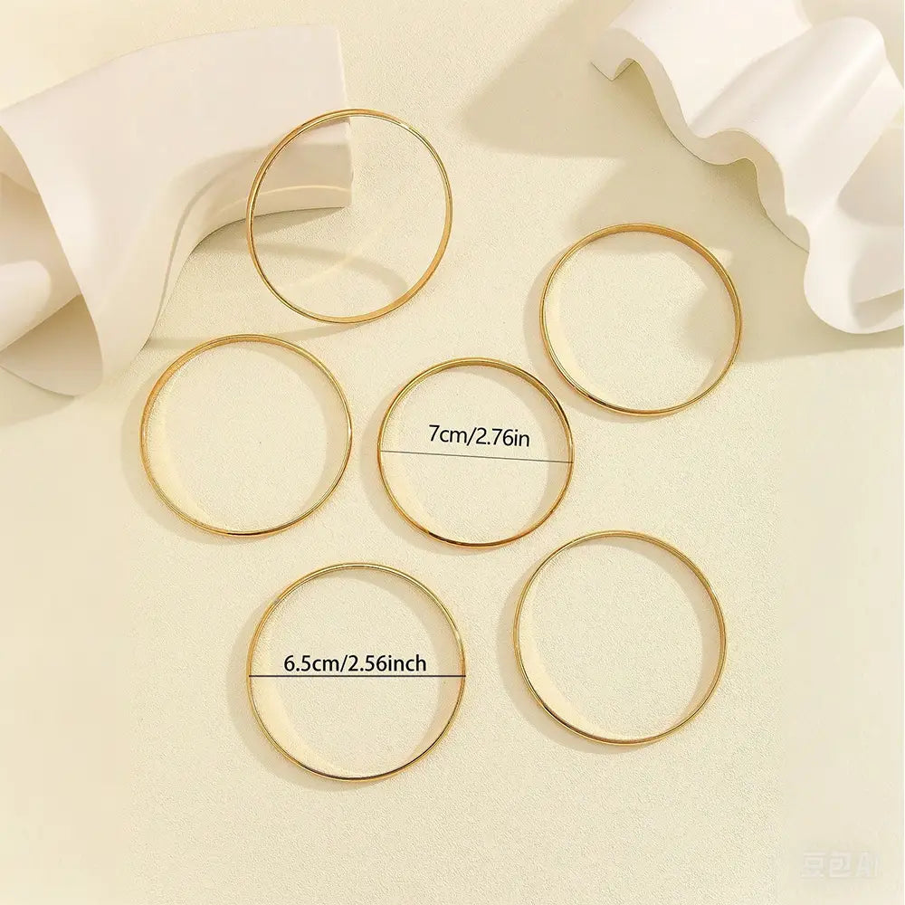 Set of six gold-toned 18k gold plated minimalist stackable metal bangles in varying sizes including 6.5cm and 7cm diameters.