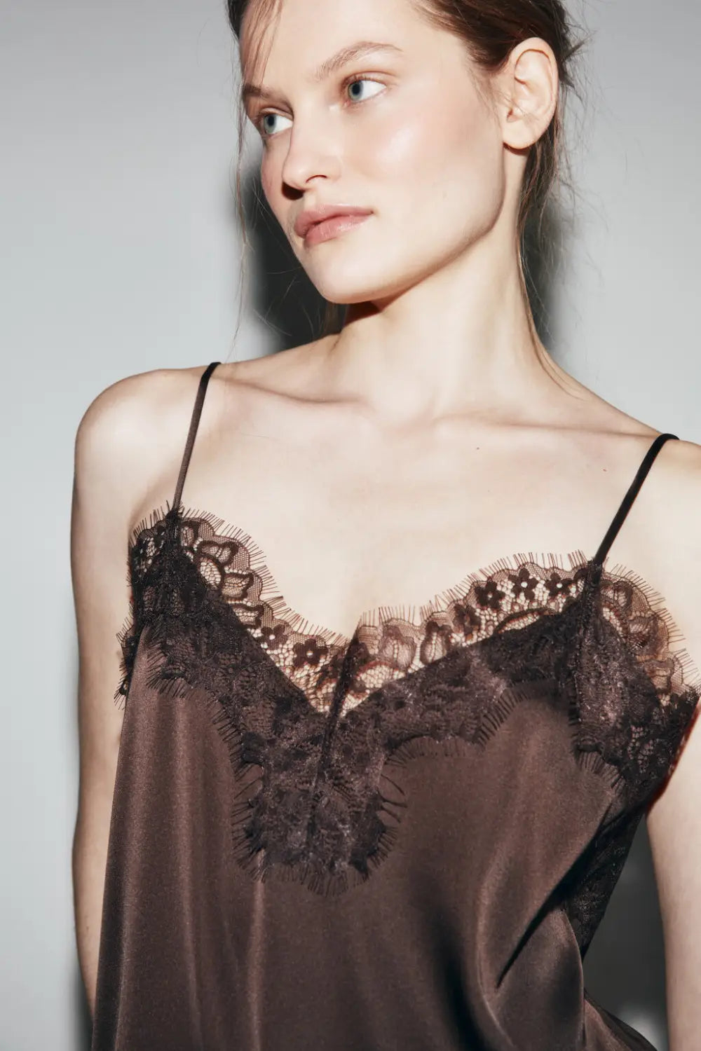 Braunes Satin-Camisole-Top mit Spitzenbesatz und zarter schwarzer Spitze entlang des Ausschnitts und der Träger.