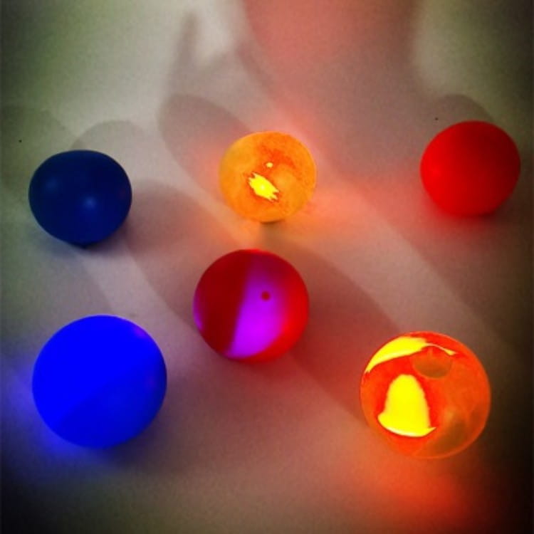 glowing multicolored led sticky wall ball stress relief glow squash toys in vibrant blue red orange and purple hues.