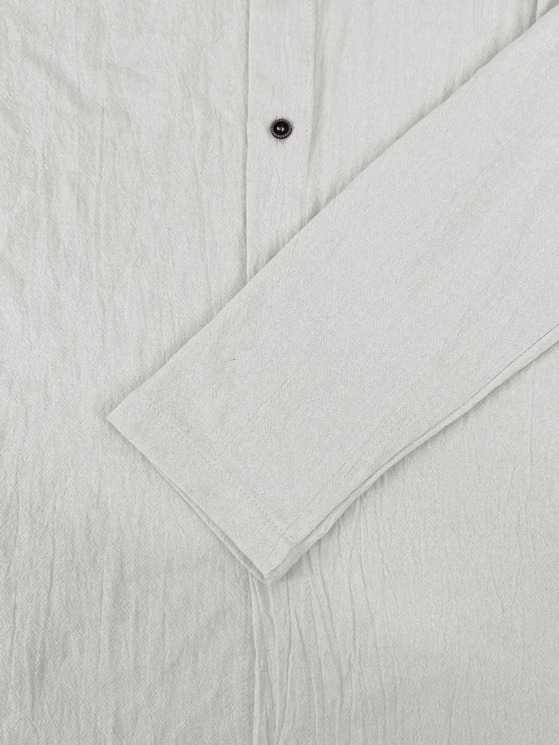 Camisa de cárdigan con capucha ligera para hombre en lino blanco, con tejido ligeramente texturizado y un solo botón oscuro en el cuello.