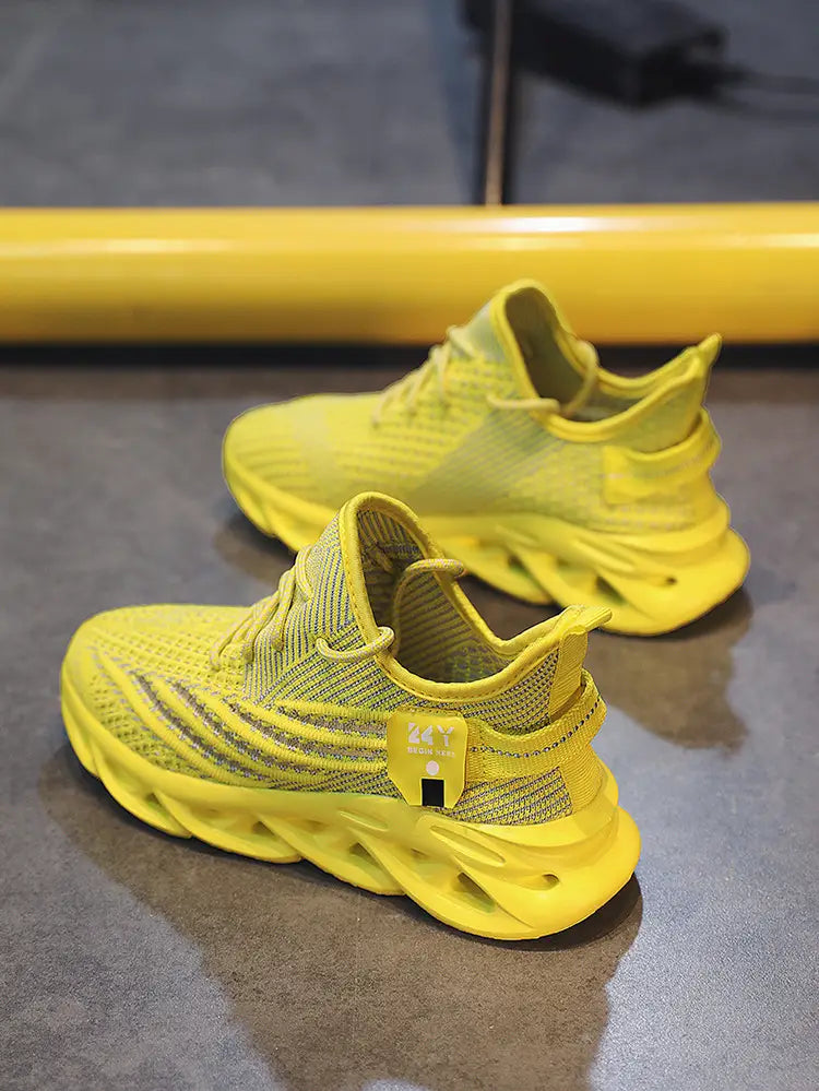 Bright yellow flyknit mesh platform running shoes for men with a breathable mesh upper and chunky sculpted rubber sole.