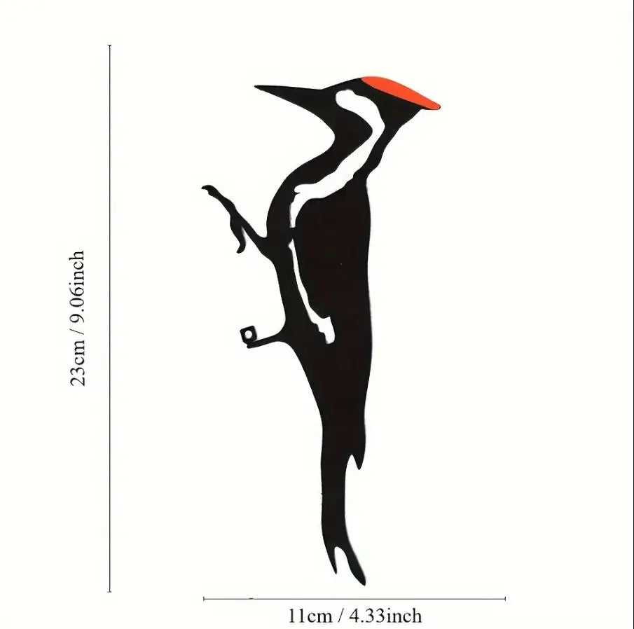 Black metal woodpecker wall art with bright orange beak and white accents designed for outdoor garden decor.