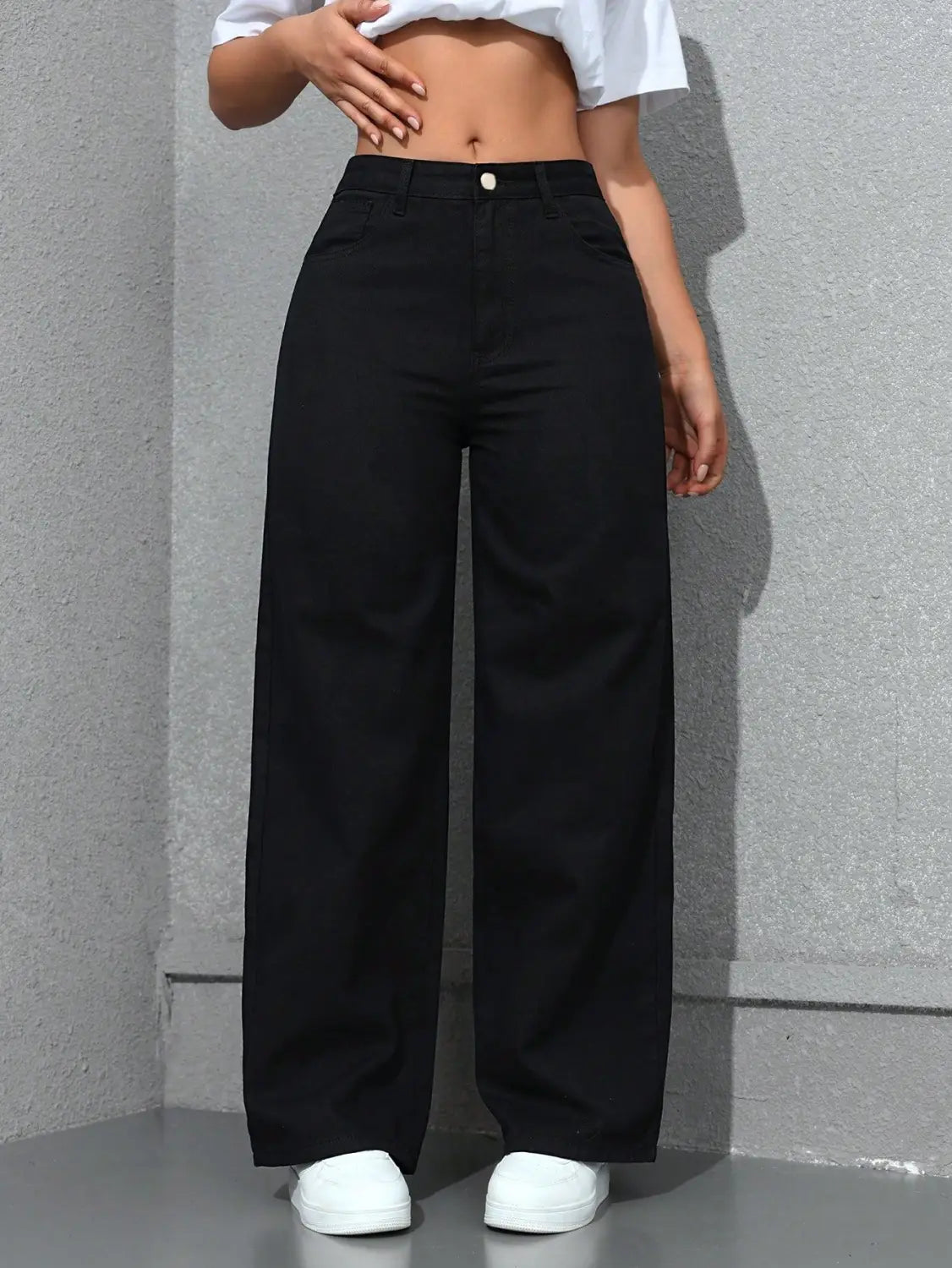 Jean noir à taille haute, jambe large et évasée, fabriqué en tissu denim, présenté de dos.