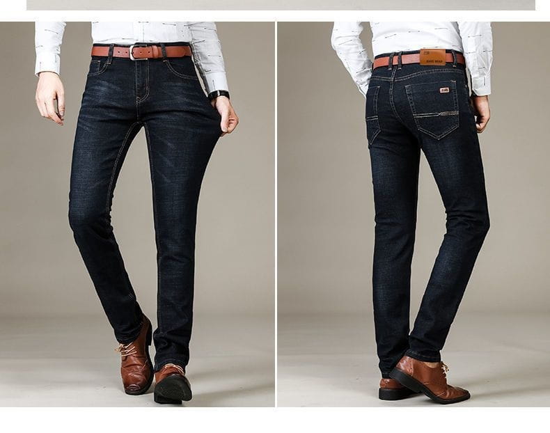 Jeans en denim indigo foncé d’affaires décontractés pour homme à taille haute, coupe slim, avec élasticité, passants de ceinture en cuir marron et coutures détaillées.