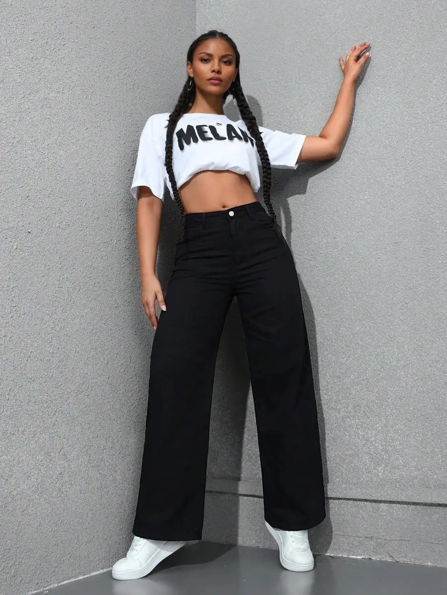 Jean noir à taille haute, jambe large et évasée, présenté de dos, avec une taille haute et une coupe ample dans un tissu denim.