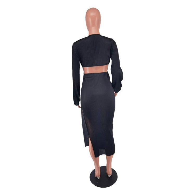 black ribbed long sleeve crop top and matching high waisted midi skirt set featuring a cutout and high slit design in ribbed material.