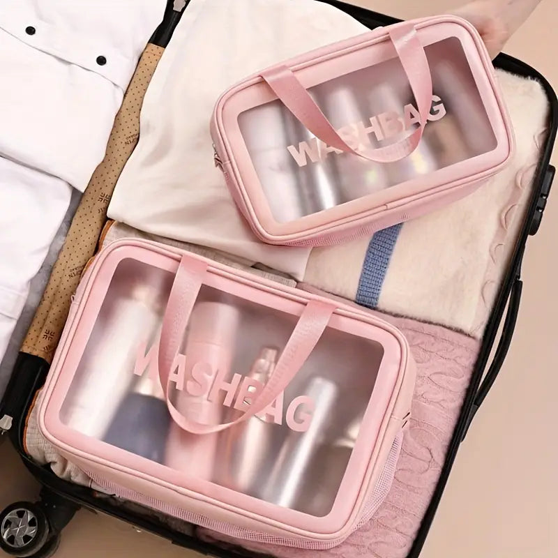 Rosa transparente Waschtasche mit rosafarbenen Stoffgriffen und aufgedrucktem washbag in passender rosafarbener Schrift, für Reisekosmetiktasche mit Trennung von trocken und nass; Wäsche-Organizer.
