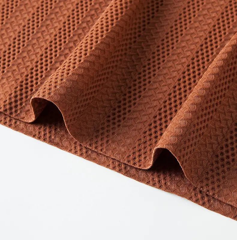 A men’s textured ice silk polo shirt in rust color featuring a breathable mesh pattern and contrast trim.