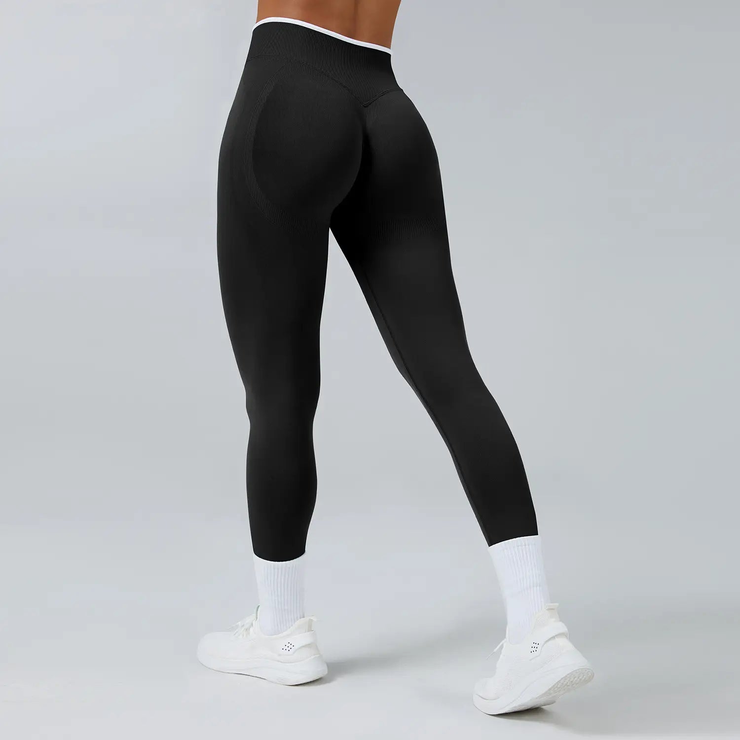Schwarze nahtlose Sport-Yoga-Leggings mit hoher Taille mit weißem Zierbesatz am Bund.