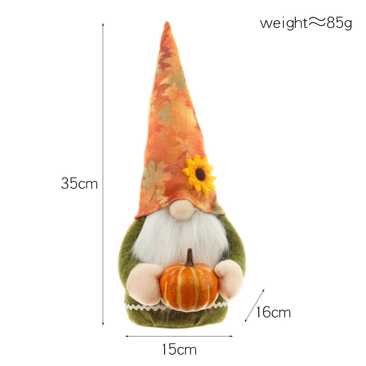 Eine kuschelige Danksagungs-Gnom-Puppe mit einer hohen orange-grünen Blattmuster-Mütze mit einer gelben Sonnenblume, gekleidet in ein grünes Samt-Outfit mit weißem Fellbesatz, und sie hält für die herbstliche Dekoration einen orangefarbenen Kürbis.