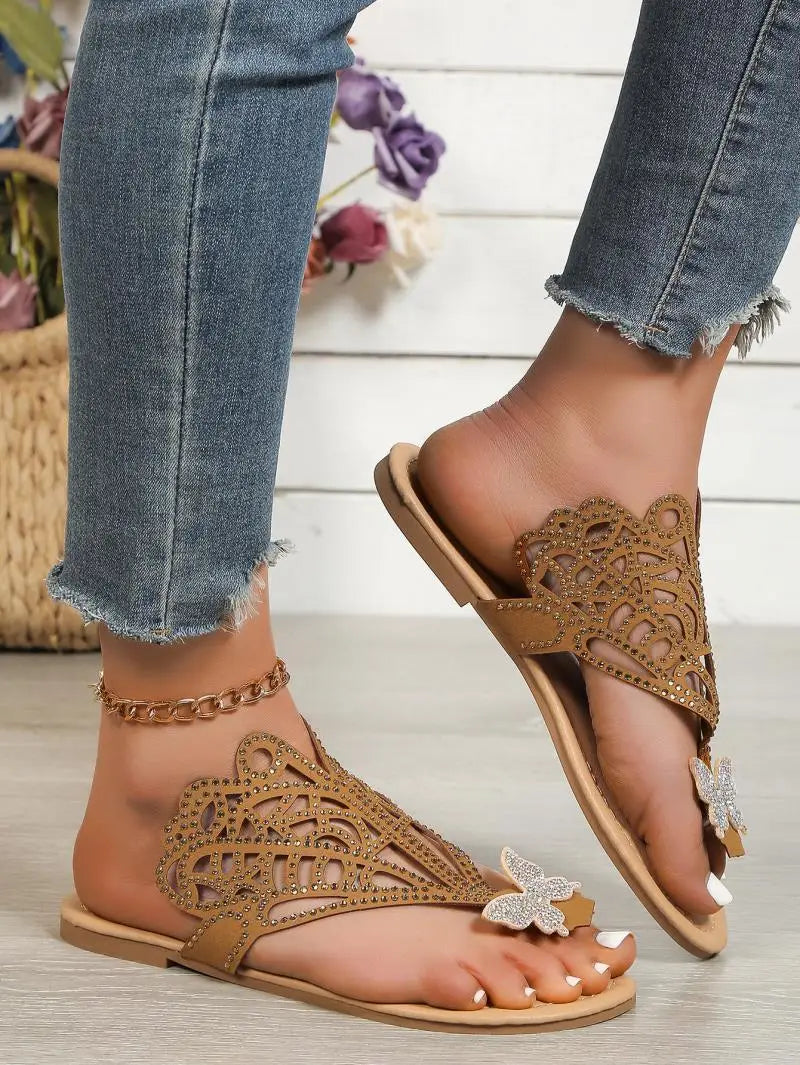 Women’s gold rhinestone hollow flat slip on sandals featuring butterfly embellishments and intricate cutout patterns.