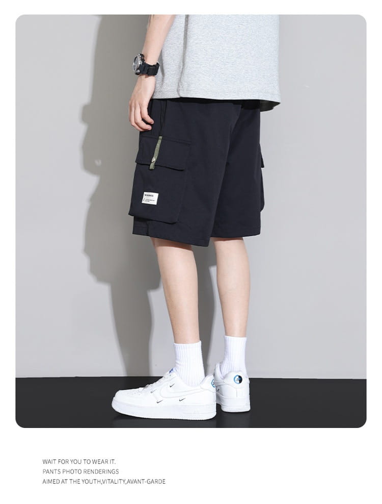 Shorts cargo décontractés pour homme grande taille en noir, avec plusieurs poches et une petite étiquette blanche sur la cuisse, coupe ample, style pantalon de sport